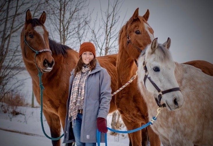 Woman posing with three horses